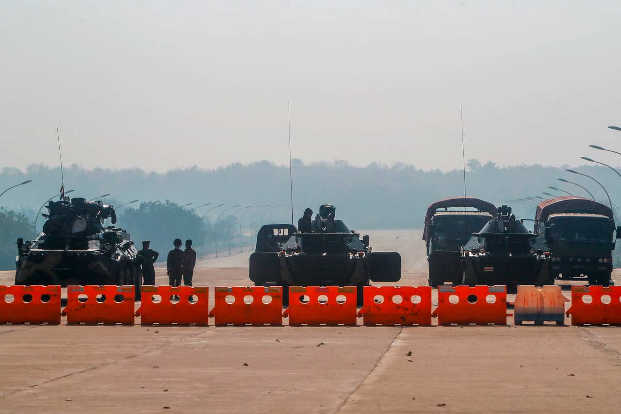 Myanmar's military stand guard at a checkpoint manned with an armored vehicles blocking a road leading to the parliament building on 2 February, 2021. 