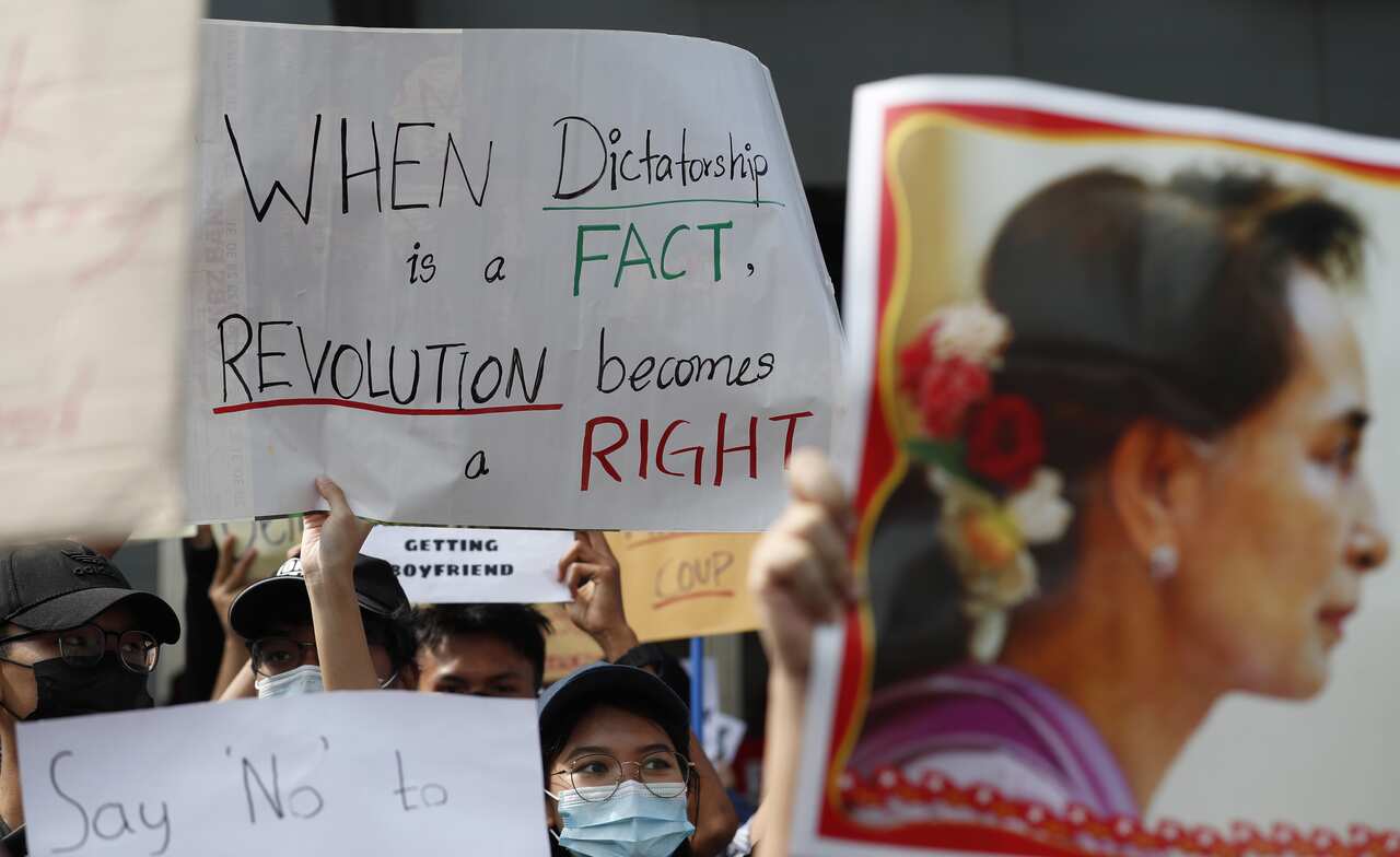 Demonstrators hold up signs and pictures of detained State Counselor Aung San Suu Kyi during a protest against the military coup at Hledan junction in Yangon, Myanmar.