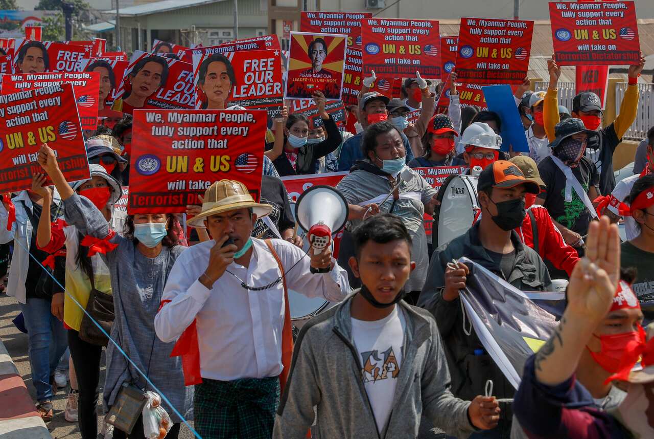 Demonstrators display placards supporting actions against Myanmar military during a protest against the military coup in Mandalay, Myanmar on 16 February, 2021.