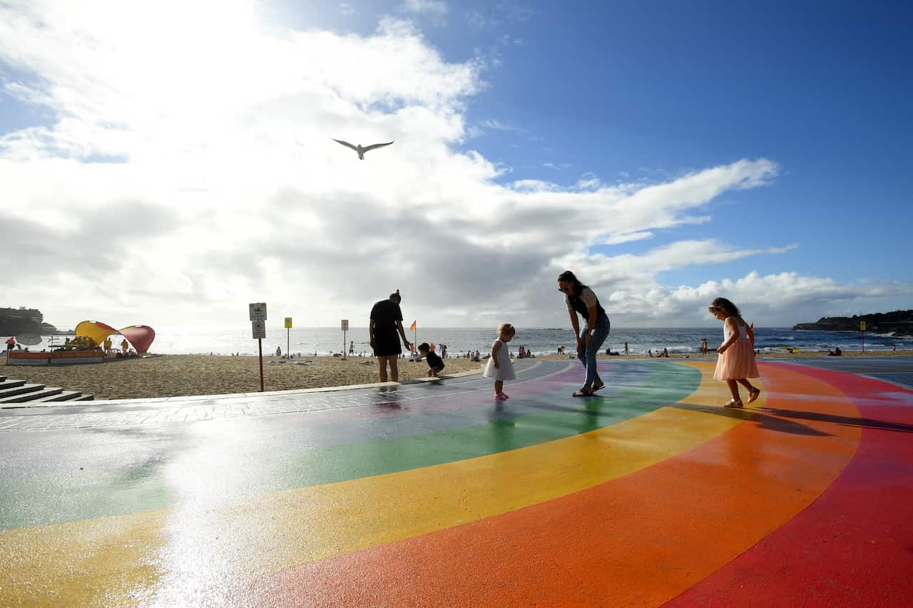 Members of the public use a beachside rainbow walkway to Celebrate Mardi Gras at Cooggee Beach in Sydney on 21 February.