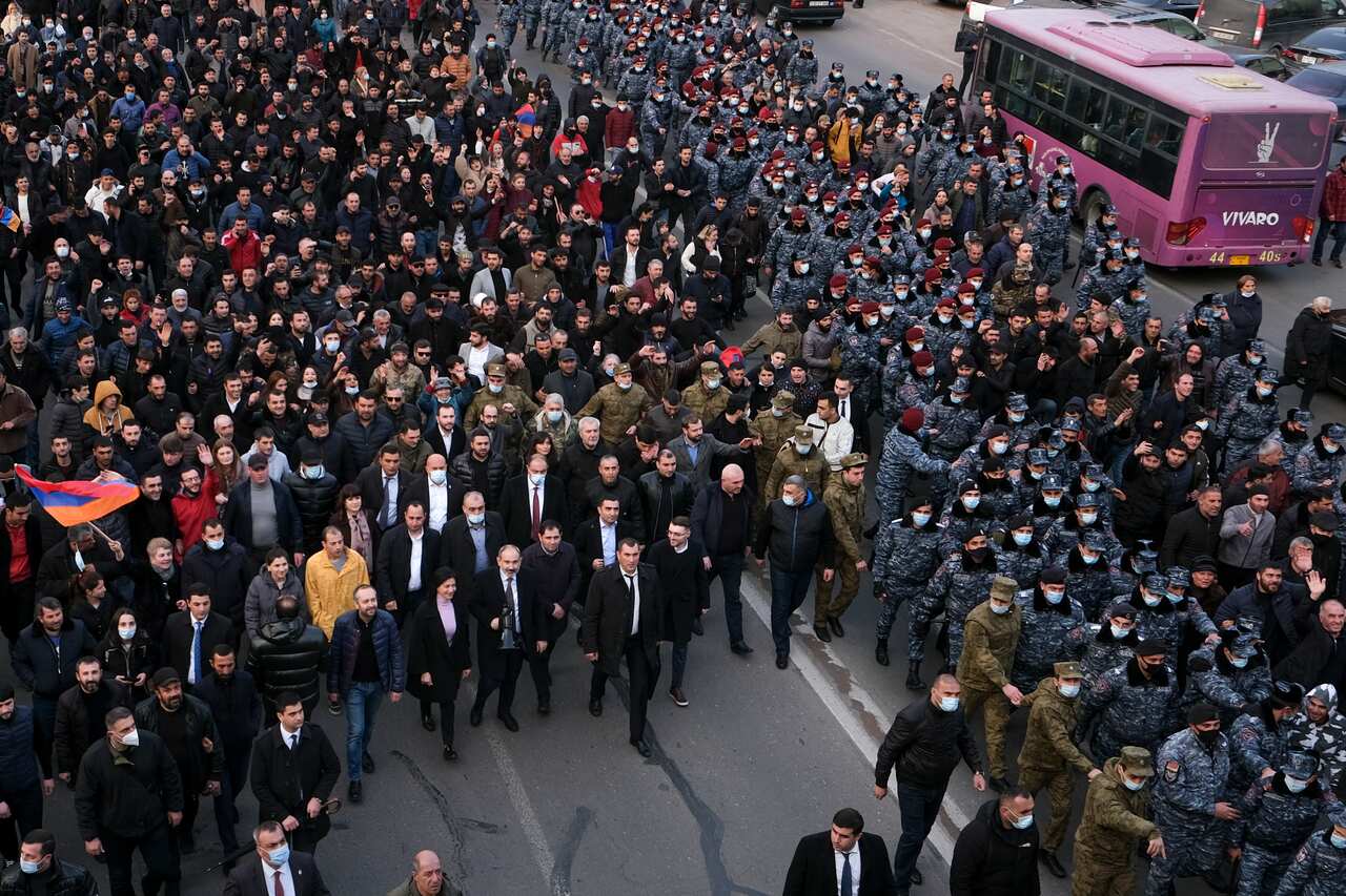 Mr Pashinyan, centre front left carrying a megaphone, walks with his wife and supporters surrounded by bodyguards and police rally in Yerevan, Armenia.