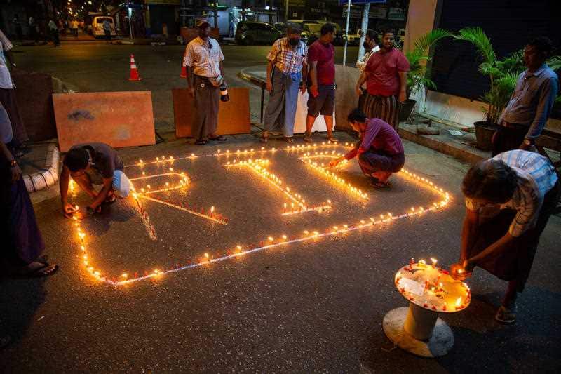 People lighting candles to pray for protesters who have died in demonstrations against the military coup in Myanmar.