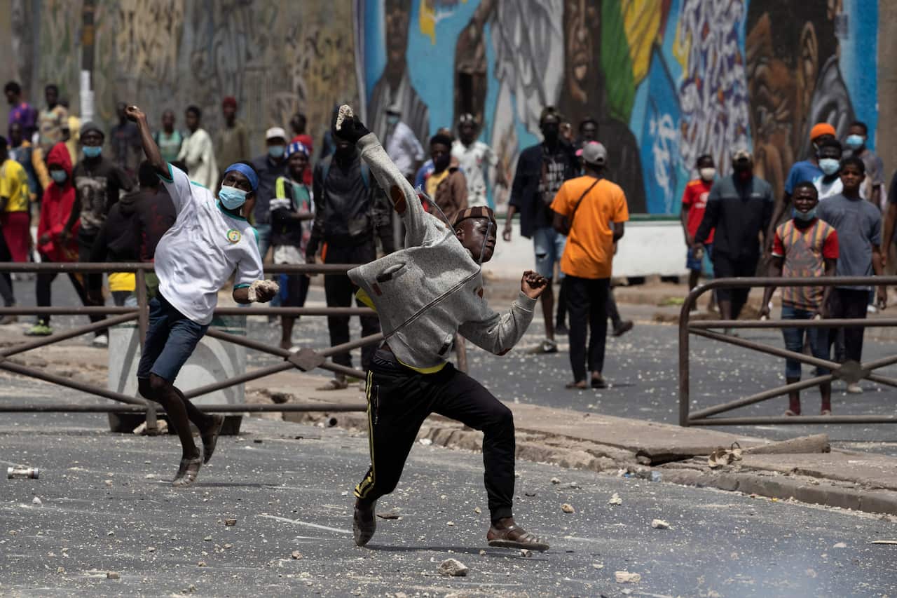 Demonstrators throw rocks during protests against the arrest of opposition leader Ousmane Sonko in Dakar, Senegal, 5 March, 2021. 