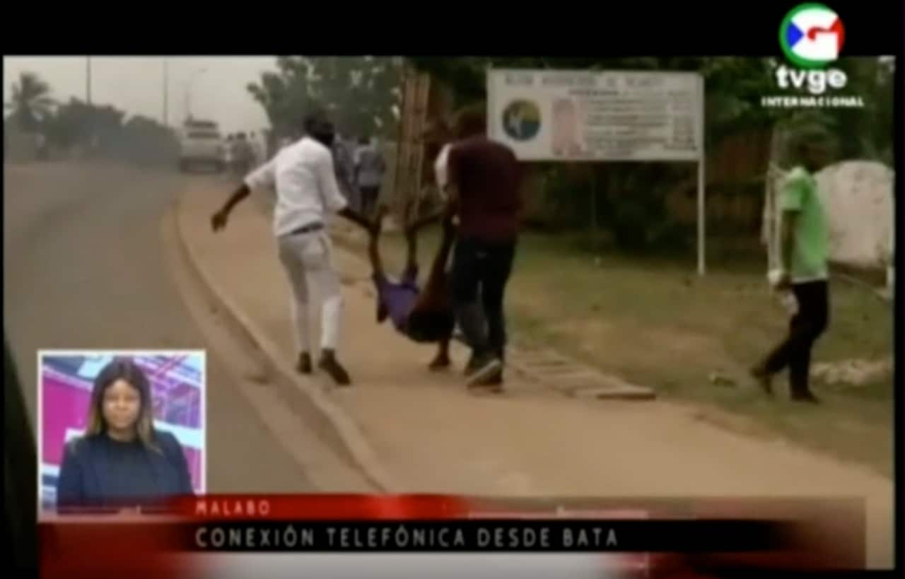 This TVGE image made from video shows people carrying a victim away after a blast site at a military barracks in Bata, Equatorial Guinea.