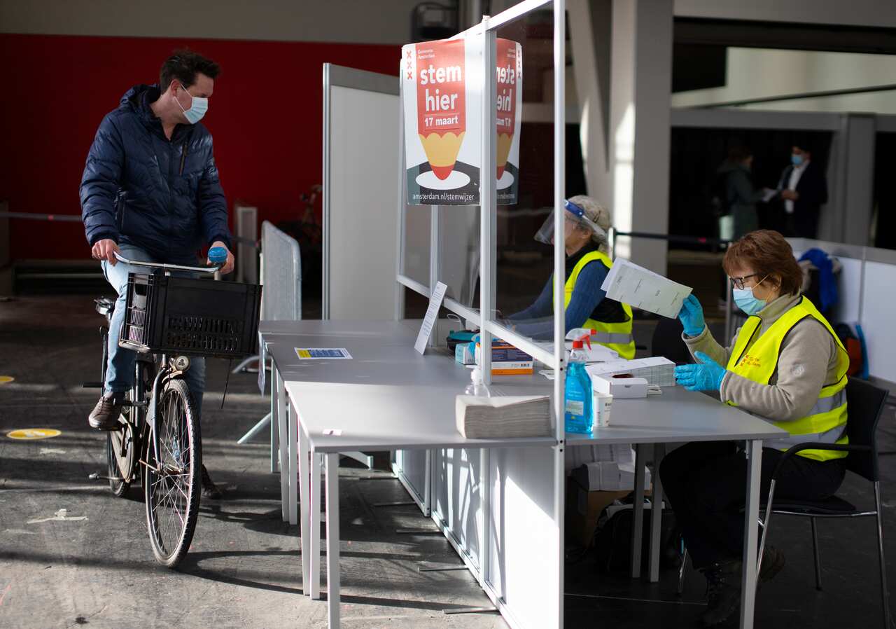 A man arrives to cast his ballot in a ride through polling station for bicycles in Amsterdam, March 15, 2021.