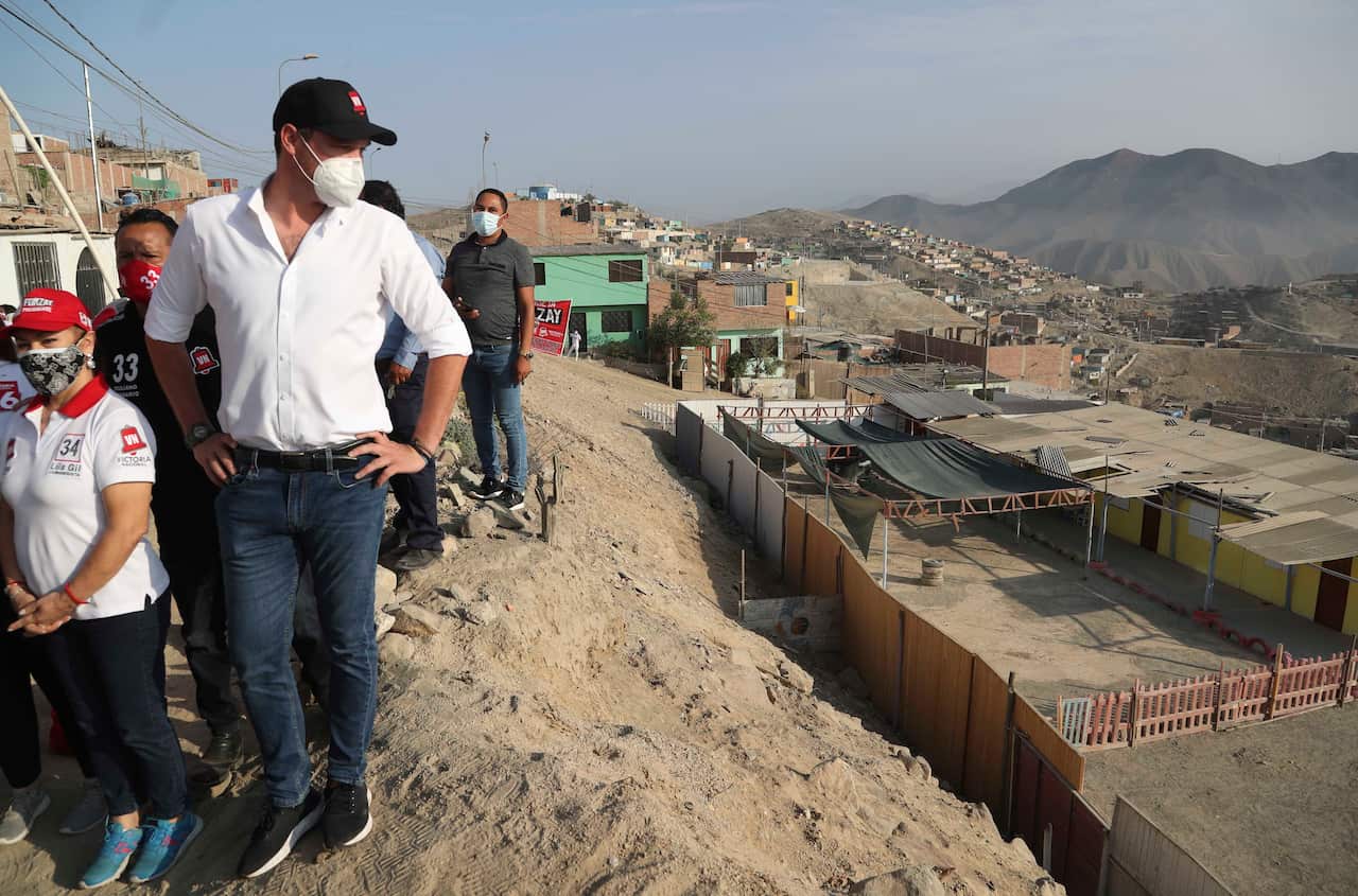 Presidential candidate George Forsyth looks out over a school as he campaigns in Manchay on the outskirts of Lima, 15 March, 2021.