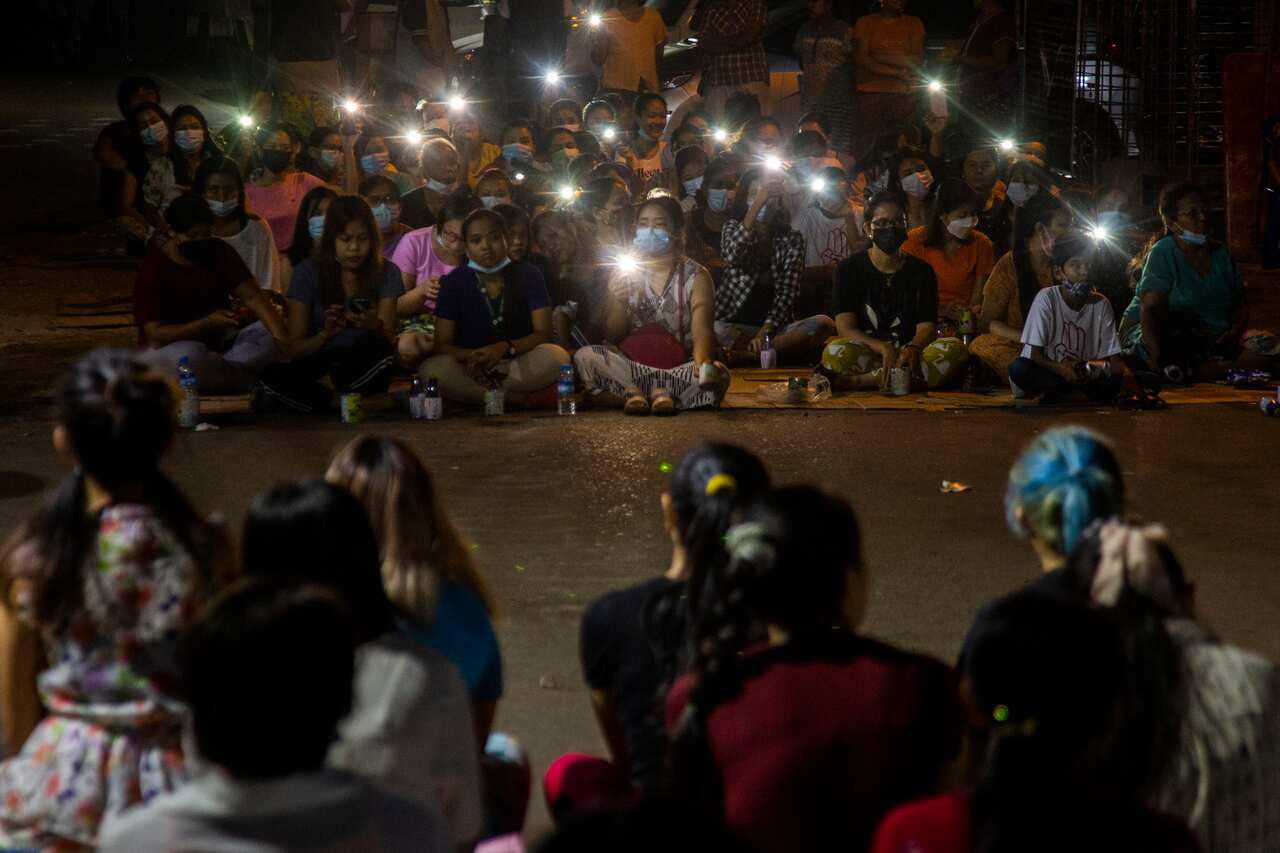 Residents flash the lights from their mobile phones during an anti-coup rally held despite an overnight curfew in Yangon on 15 March. 