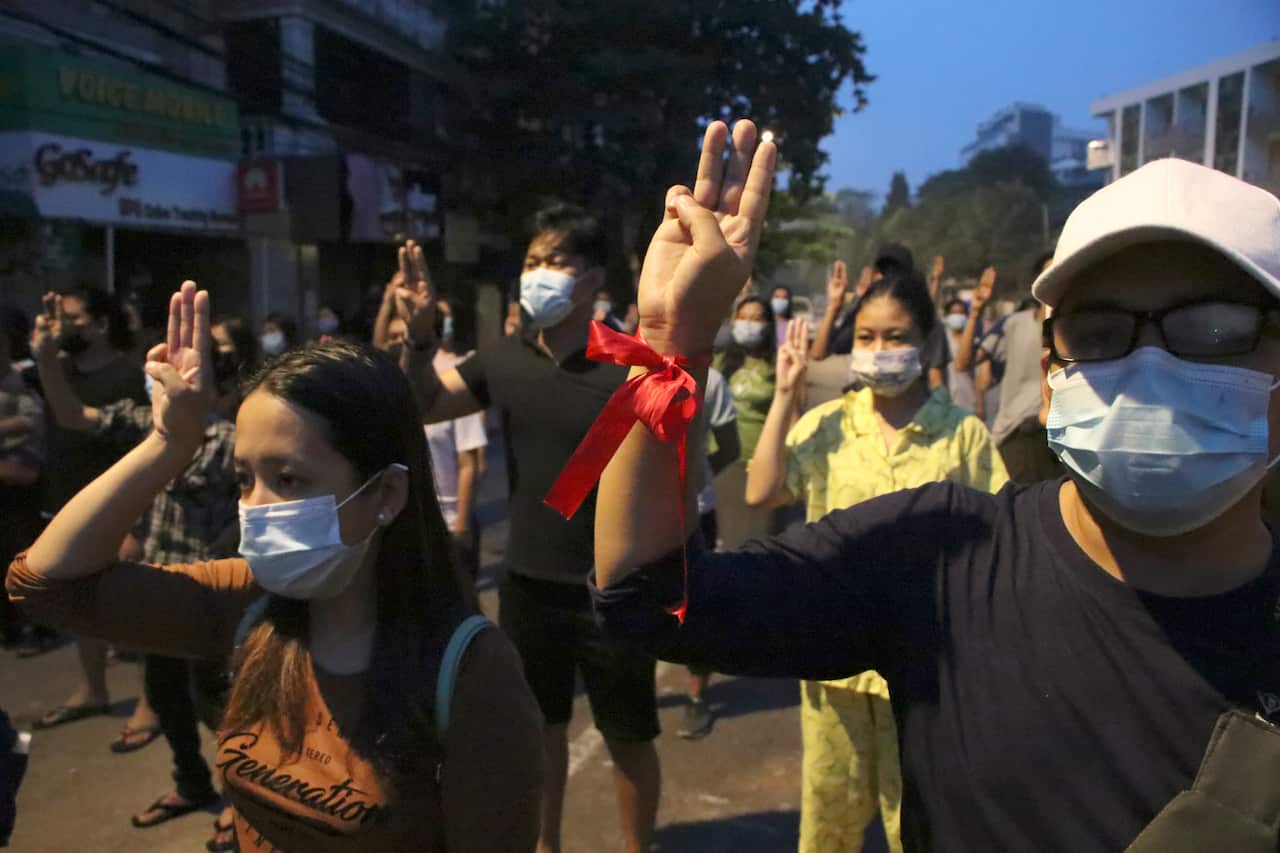 Anti-coup protesters flash their three-fingered symbol of resistance during protests in Yangon, Myanmar on Monday, 22 March.