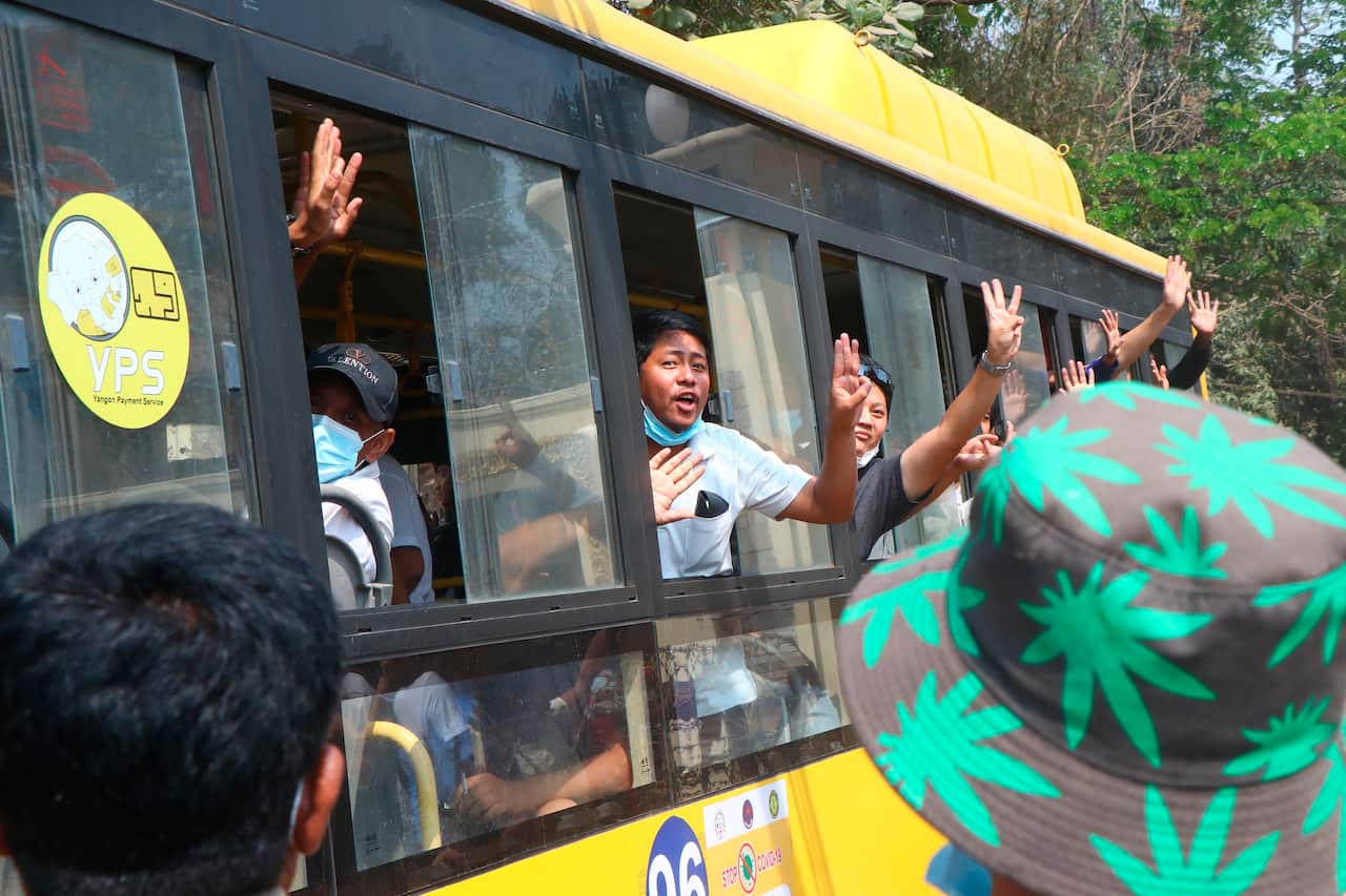 Arrested protesters flash a three-fingered salute, a sign of resistance for the anti-coup movement, while on a bus that getting out of Insein prison on 23 March in Yangon, Myanmar.