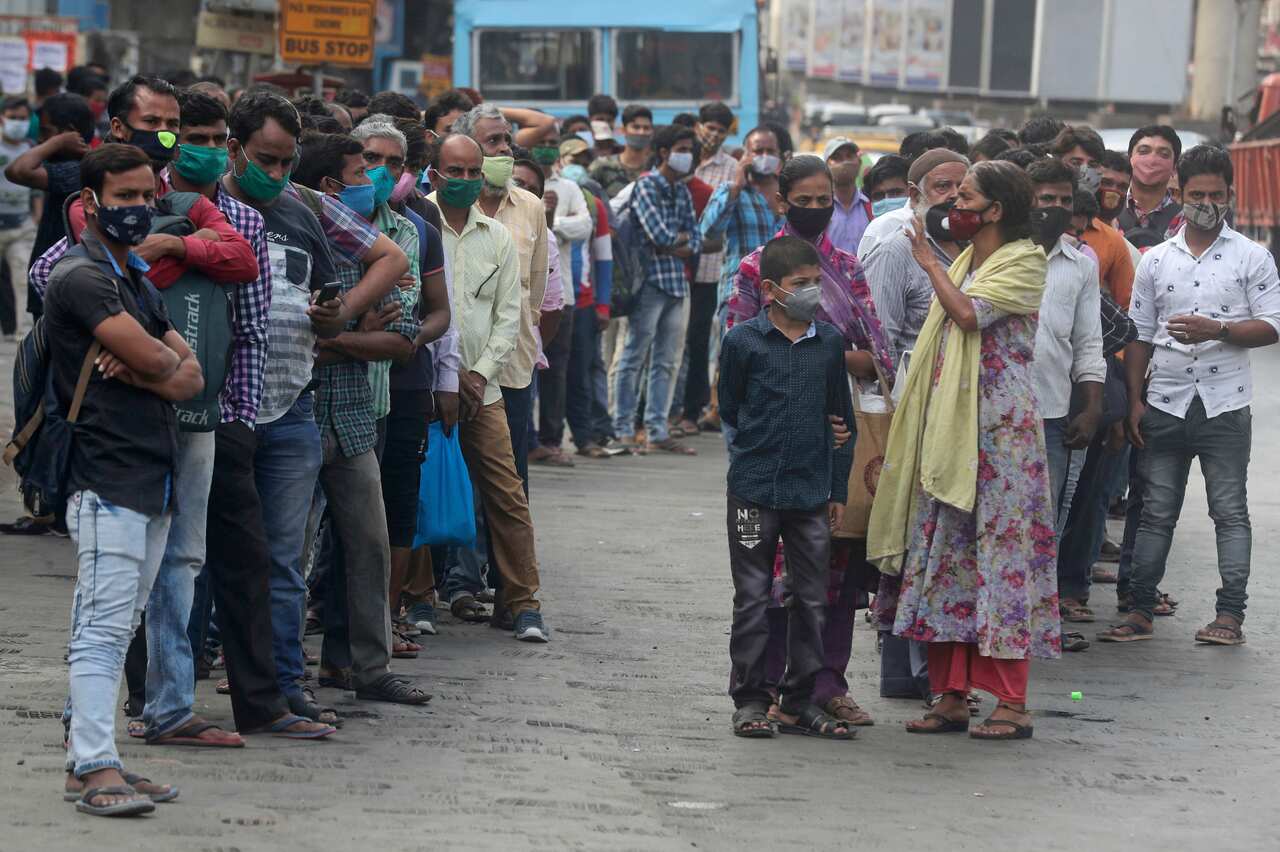 People wearing masks queue up to board buses in Mumbai, India, Monday 5 April, 2021.