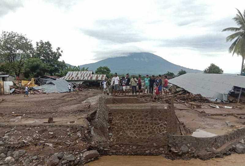 People inspect damaged area after a flash flood hit their village in Adonara, East Flores, Indonesia, 6 April 2021