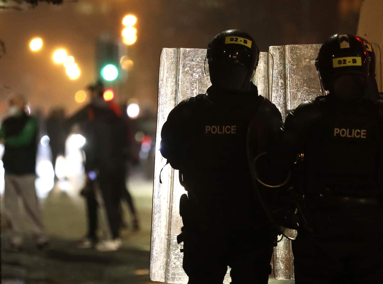 Police separate Nationalists and Loyalists near the peace wall in West Belfast, Northern Ireland, Wednesday, April 7, 2021