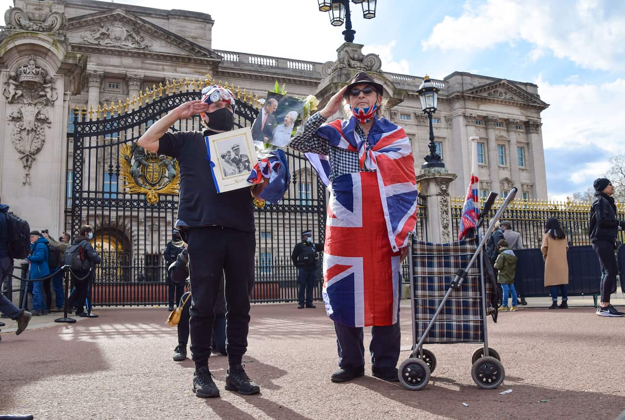 Two men pay their respect to Prince Philip outside Buckingham Palace, London, 9 April 2021.