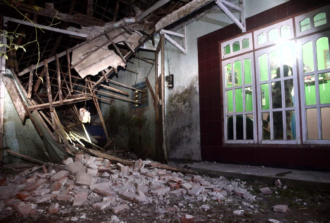 A woman surveys a part of her house damaged by an earthquake in Malang, East Java, Indonesia, Saturday, 10 April, 2021. 