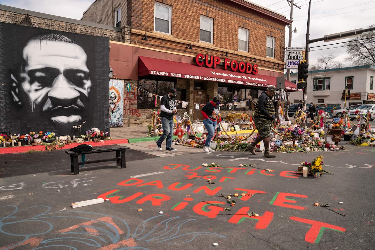Visitors browse a memorial to George Floyd as a new addition commemorating Daunte Wright is displayed outside Cup Foods in Minneapolis.