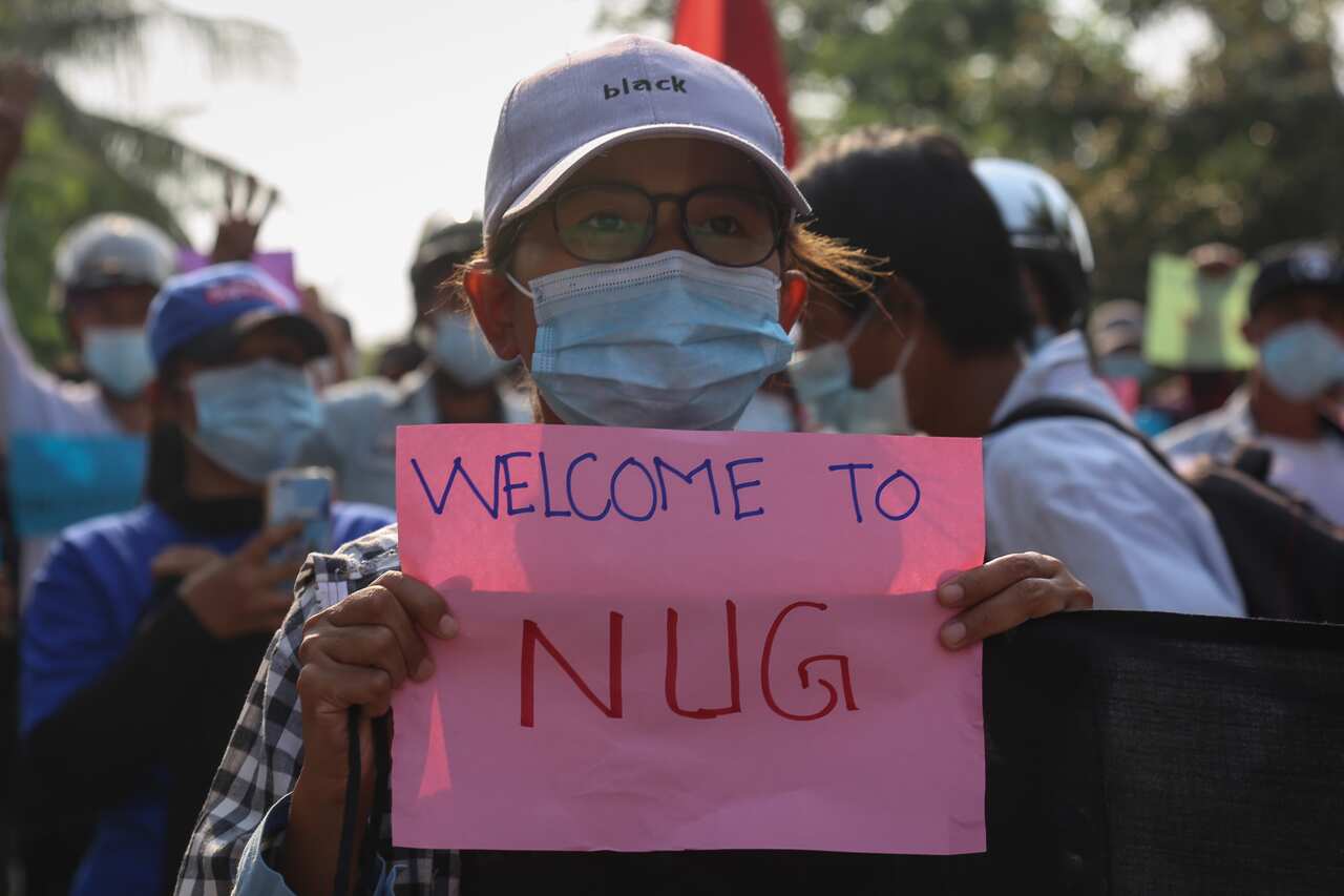 A demonstrator holds a banner that shows support for the National Unity Government (NUG), formed by leaders of the anti-coup protest and ethnic minority leaders