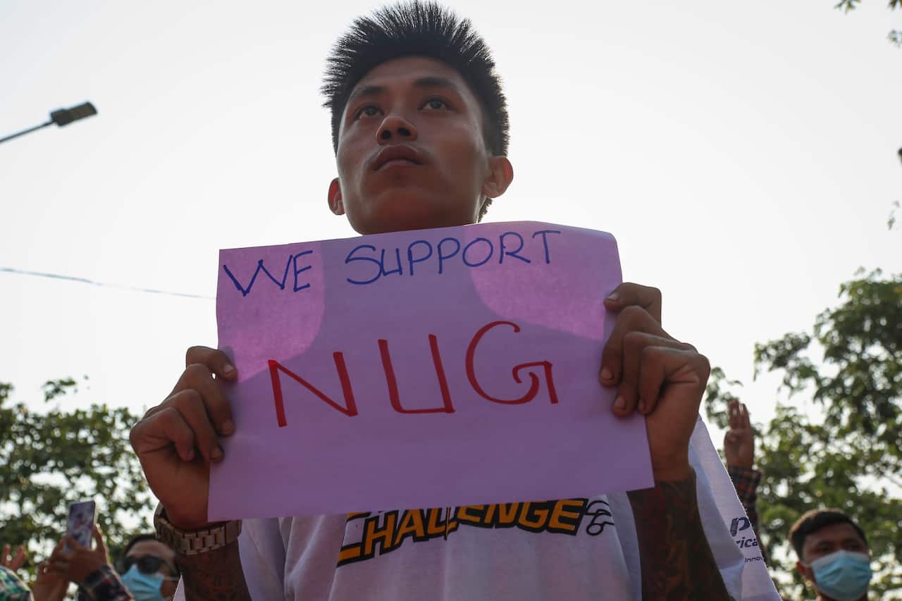 A demonstrator holds a banner that shows support for the National Unity Government during an anti-military coup protest in Mandalay, Myanmar, 18 April 2021.