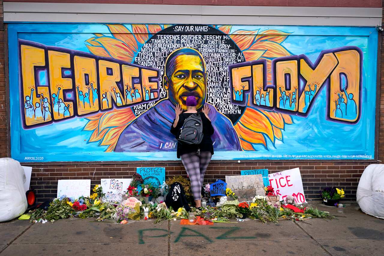 A woman pays respect to George Floyd at a mural at George Floyd Square, April 23, 2021, in Minneapolis.