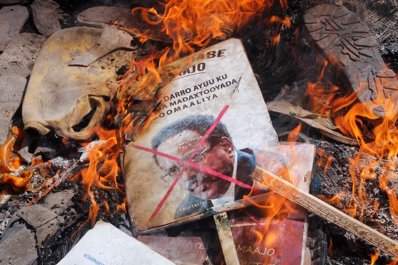 Demonstrators from Somali anti-government opposition groups burn photographs of the president