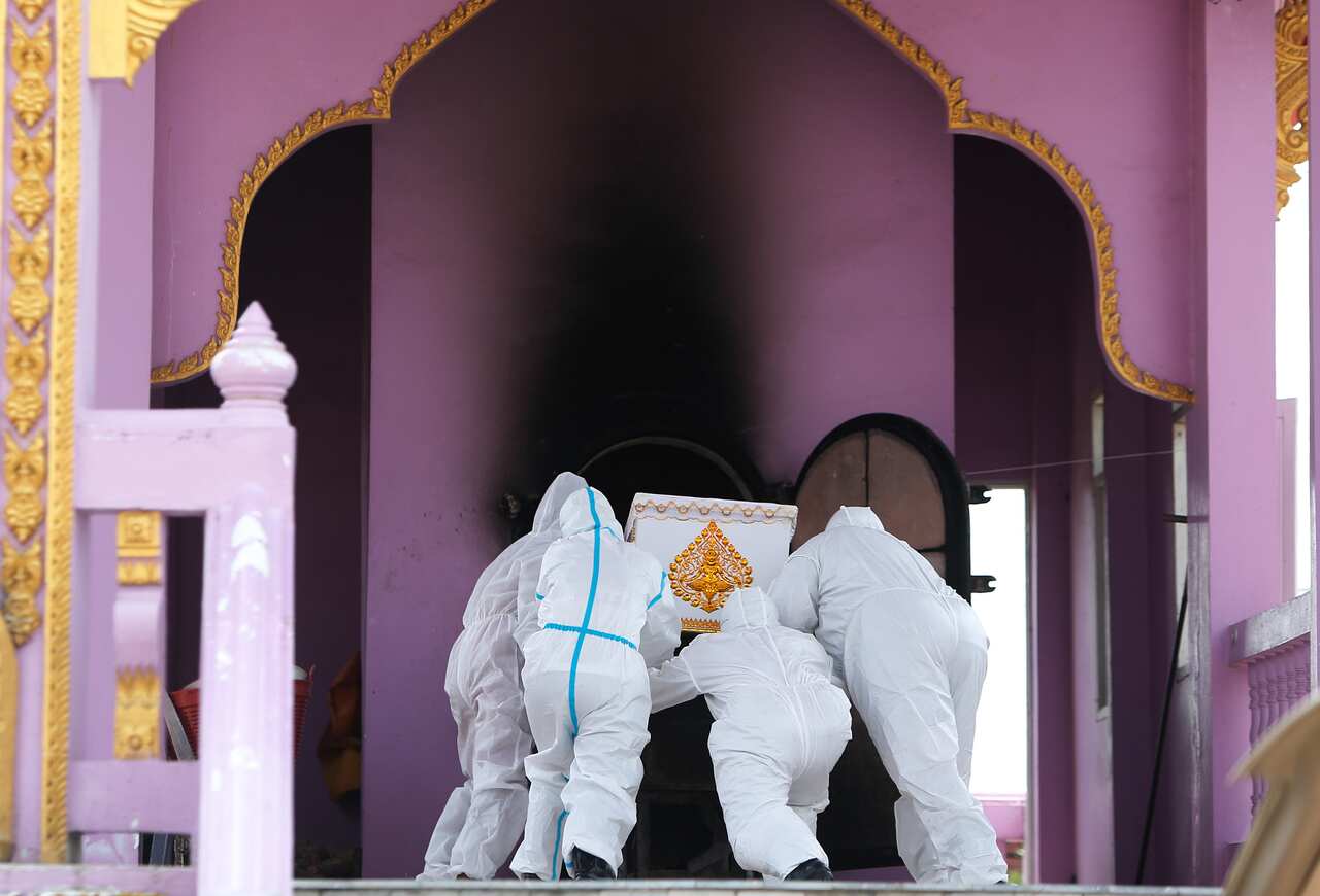Rescue workers in PPE carry a coffin of a Covid-19 victim at Wat Bang Muang, in Nonthaburi province, Thailand.