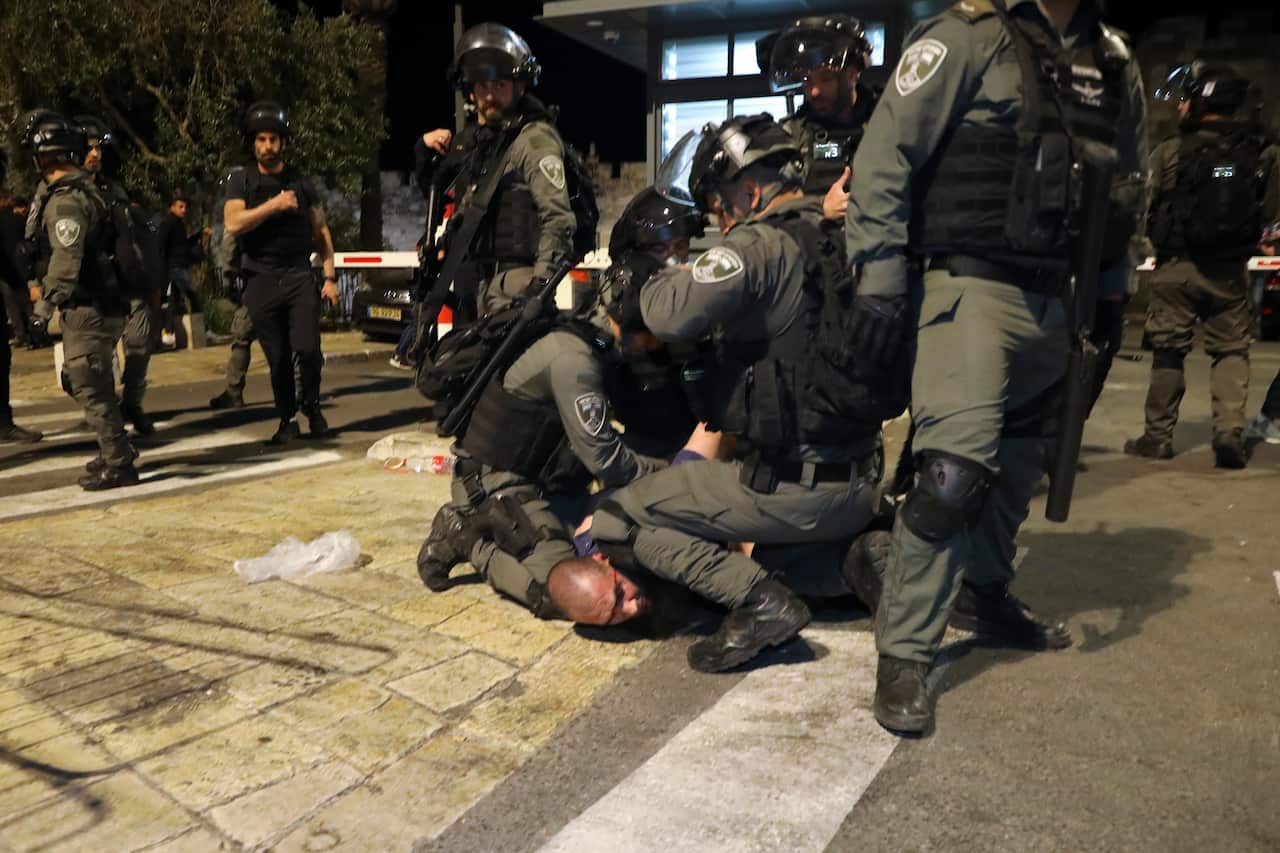 Israeli border police officers detain a Palestinian demonstrator during clashes with Palestinian protesters, in east Jerusalem, Friday, May 7. 2021.