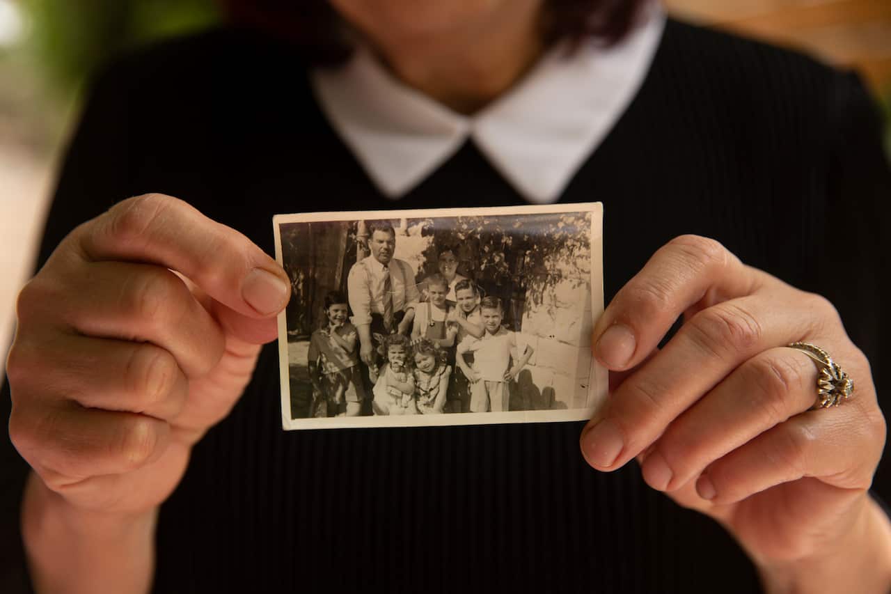 Rasha's mother Samira Dajani holds a photo of her family in 1956 after they moved into their home in Sheikh Jarrah.
