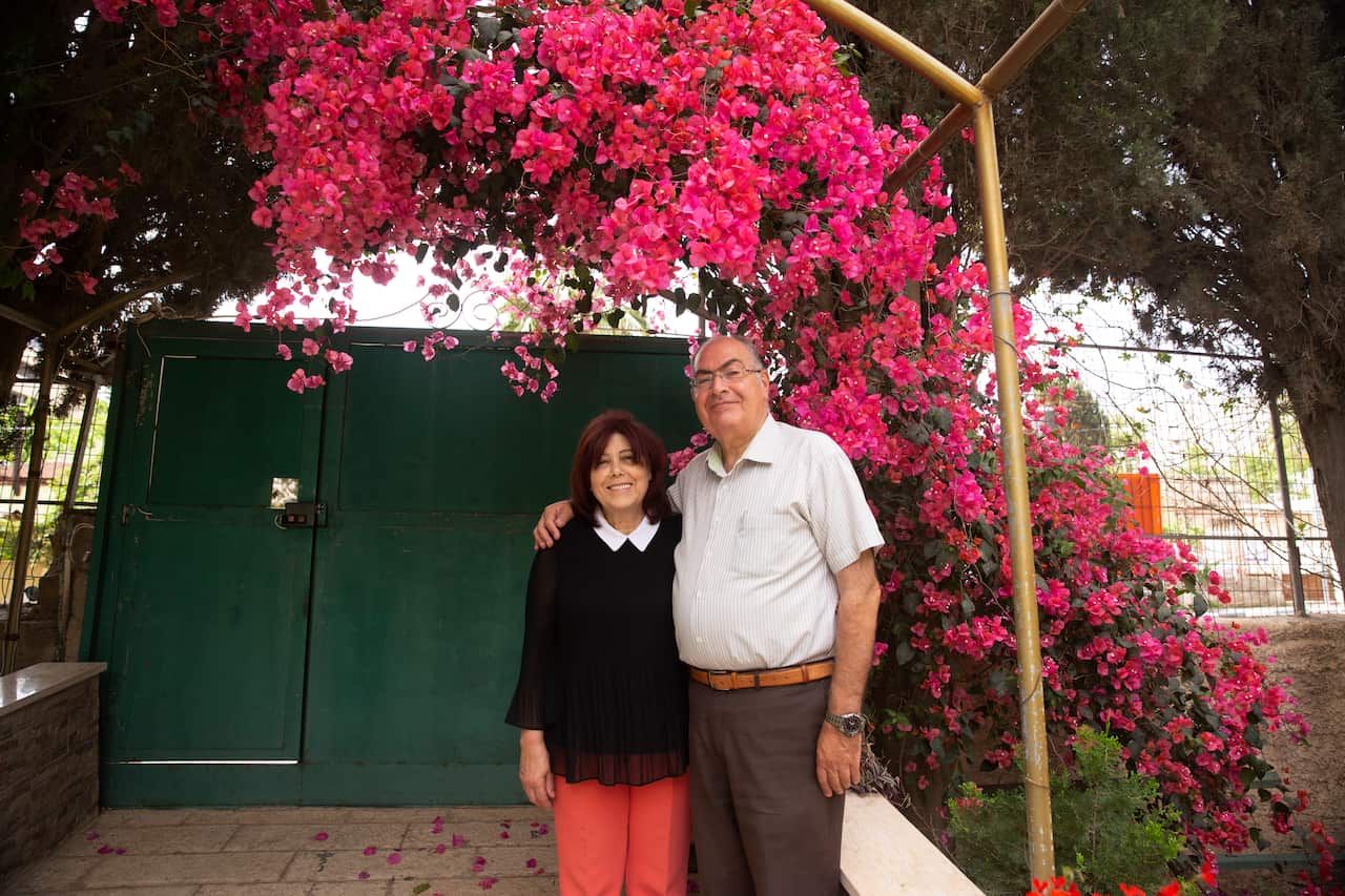 Samira Dajani and her husband, Adel Budeiri, pose for a portrait in the garden of their home, where she has lived since childhood.