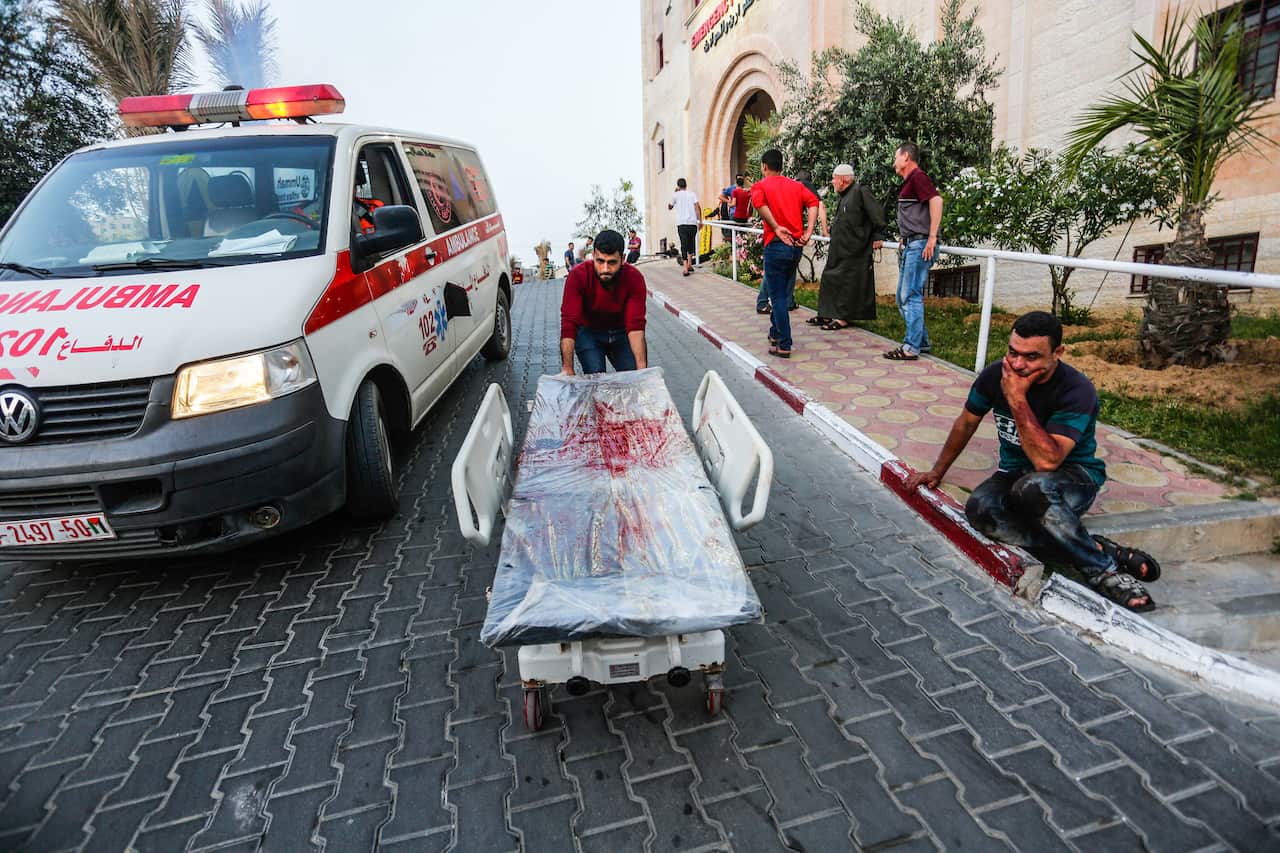 A Palestinian response worker pulls a stretcher bed covered with blood from victims of the Israeli-Palestinian violence in the northern Gaza Strip.