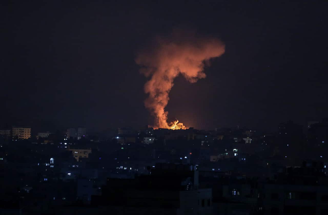 Smoke and flames rise after an Israeli airstrike in the northern Gaza strip, 14 May 2021. 