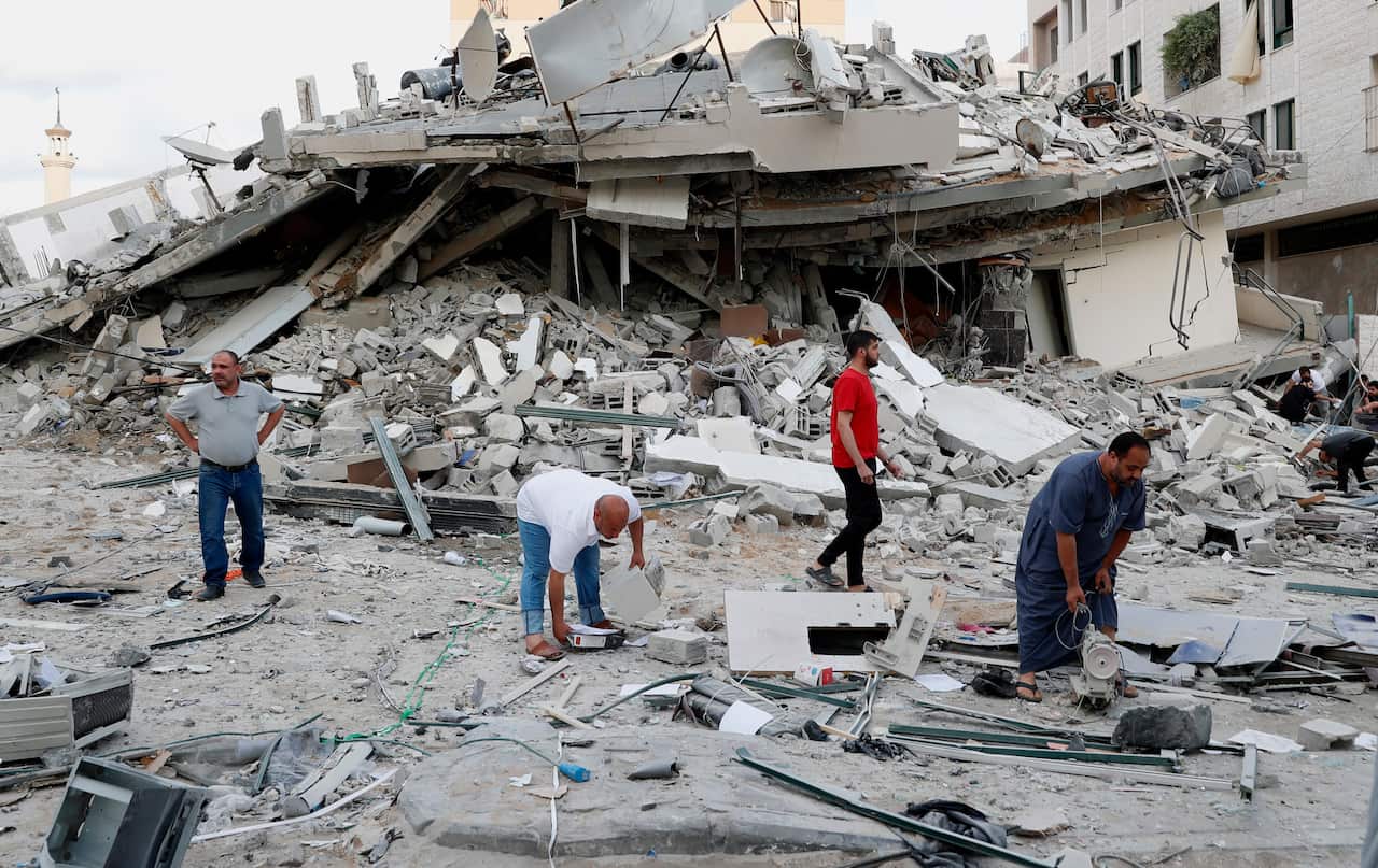 People inspect the rubble of destroyed residential building that was hit by an Israeli airstrike in Gaza City.