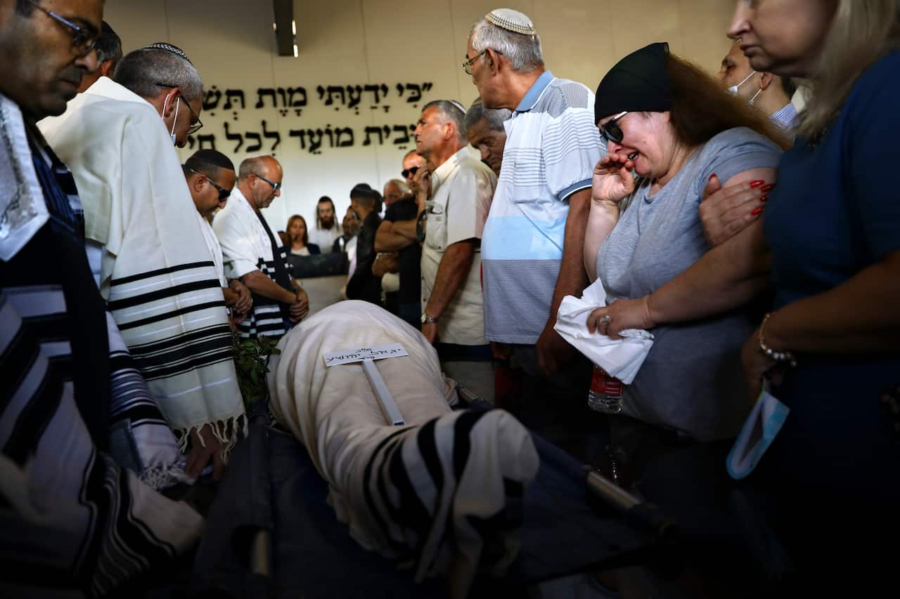 Mourners attend the funeral of Yigal Yehoshua, 56, at a cemetery in Hadid, central Israel, Tuesday, May 18, 2021.