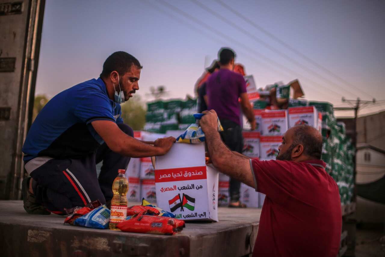 Workers unload boxes of Egyptian aid after arriving at Rafah border between Egypt and Gaza Strip.