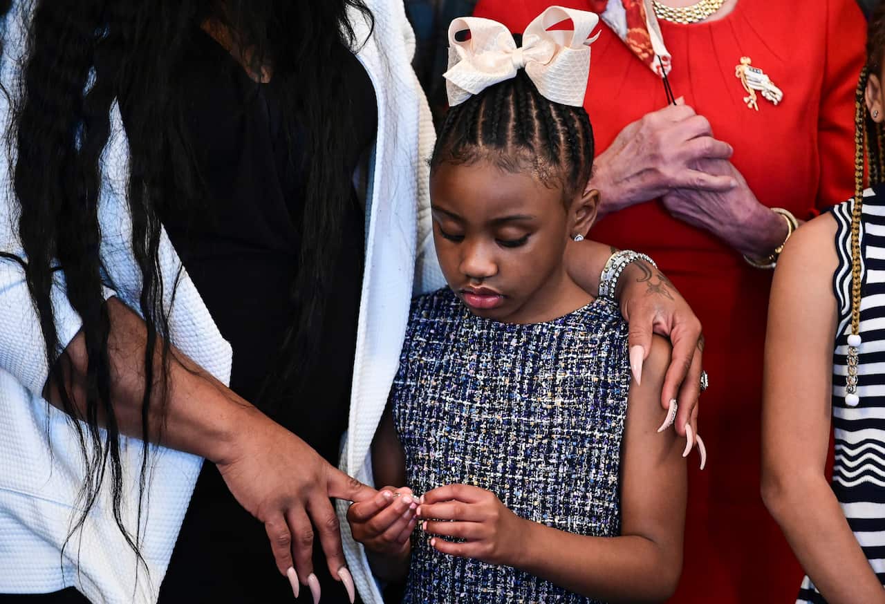 Gianna Floyd, George Floyd's daughter, holds the hand of her mother, Roxie Washington before a meeting to commemorate her father’s death.