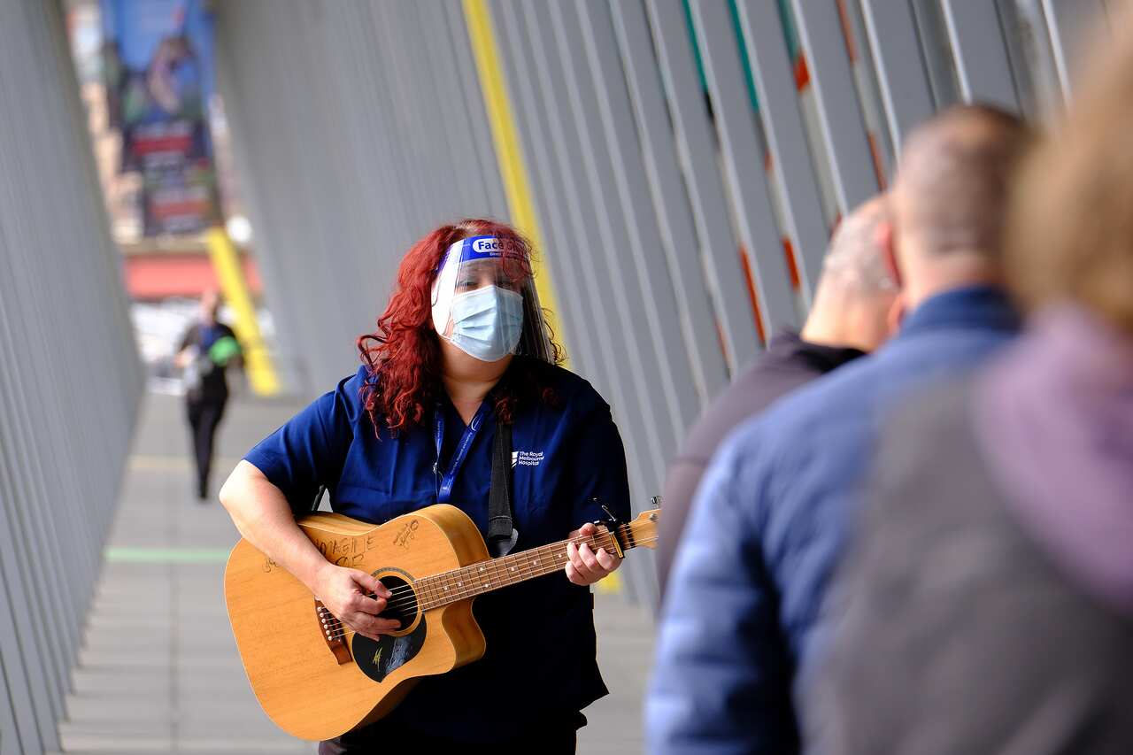 The Royal Melbourne Hospital's music therapy team were outside the Melbourne Convention and Exhibition Centre hub on Friday