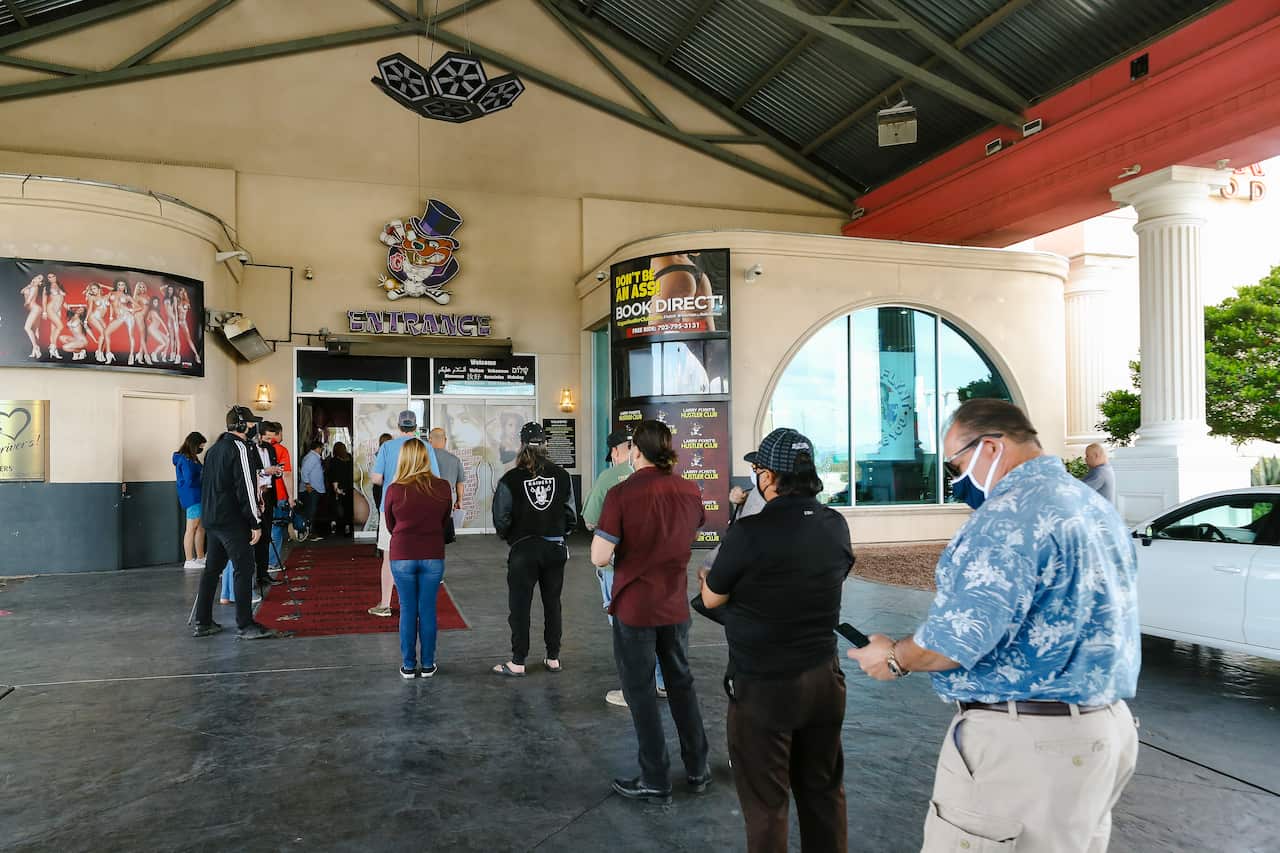 people wait in line during a pop-up COVID-19 vaccine event at Larry Flynt's Hustler Club in Las Vegas. It's one of several methods health officials are employing here and across the country to bring vaccines directly to people to counter waning demand. 