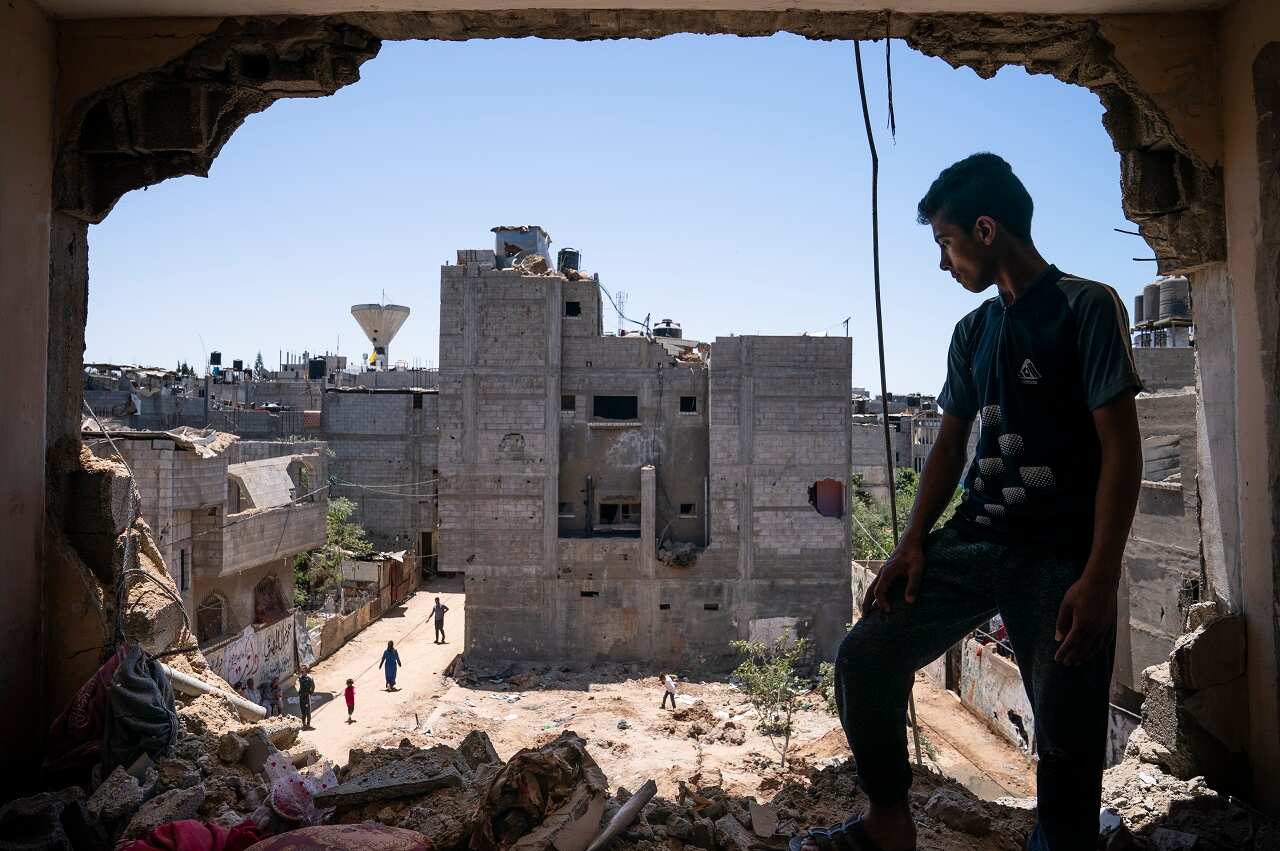 A boy stands in his bedroom after an airstrike destroyed a neighbouring building, May 26, 2021, in Beit Hanoun, Gaza Strip. 