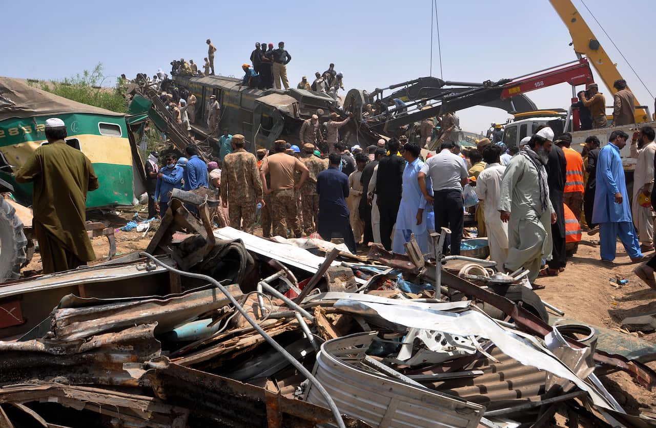 Soldiers and volunteers work at the site of the train collision.