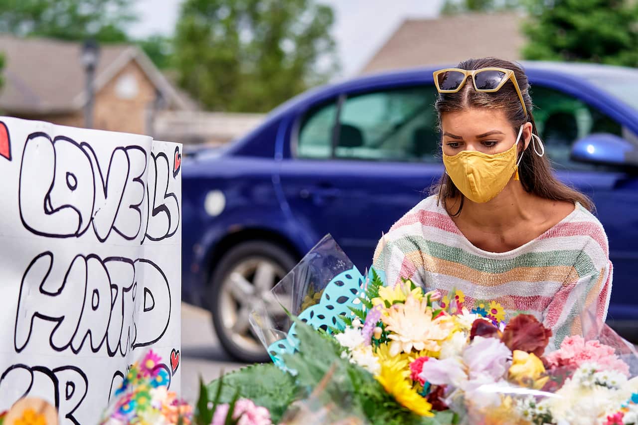 A woman places flowers at the scene of the alleged attack in London, Ontario on Tuesday, 8 June, 2021.