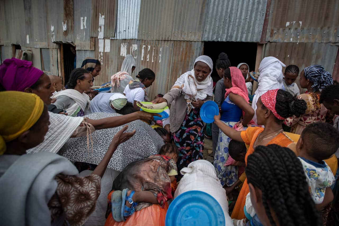 Displaced Tigrayans queue to receive food donated by local residents at a reception center for the internally displaced in Mekele, Tigray.