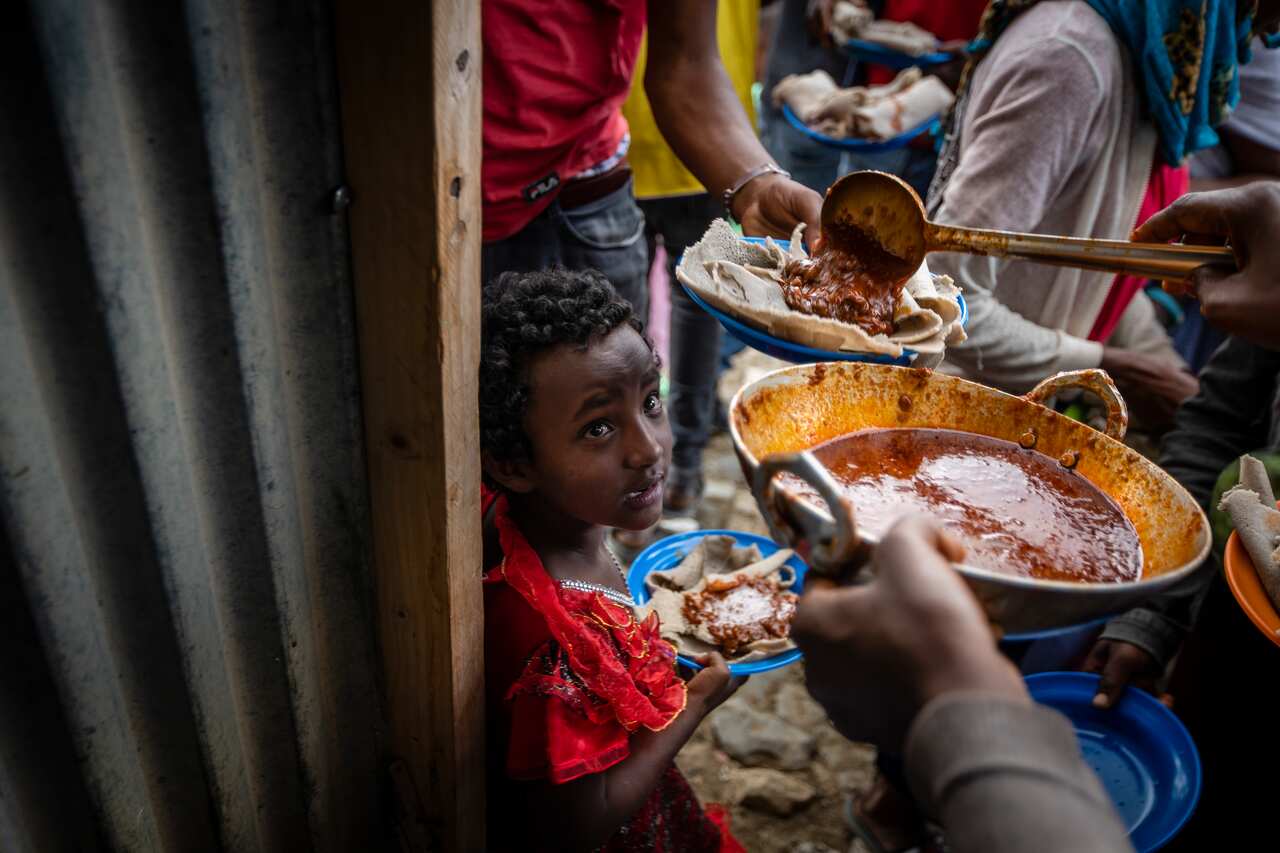 People receive food donated by local residents at a reception centre for the internally displaced in Mekele, in the Tigray region of northern Ethiopia