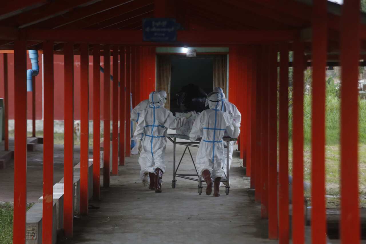 Workers shift a coffin with a COVID-19 victim at the Sittwe Hospital to a cemetery at Sittwe Rakhine, Myanmar, 6 July 2021
