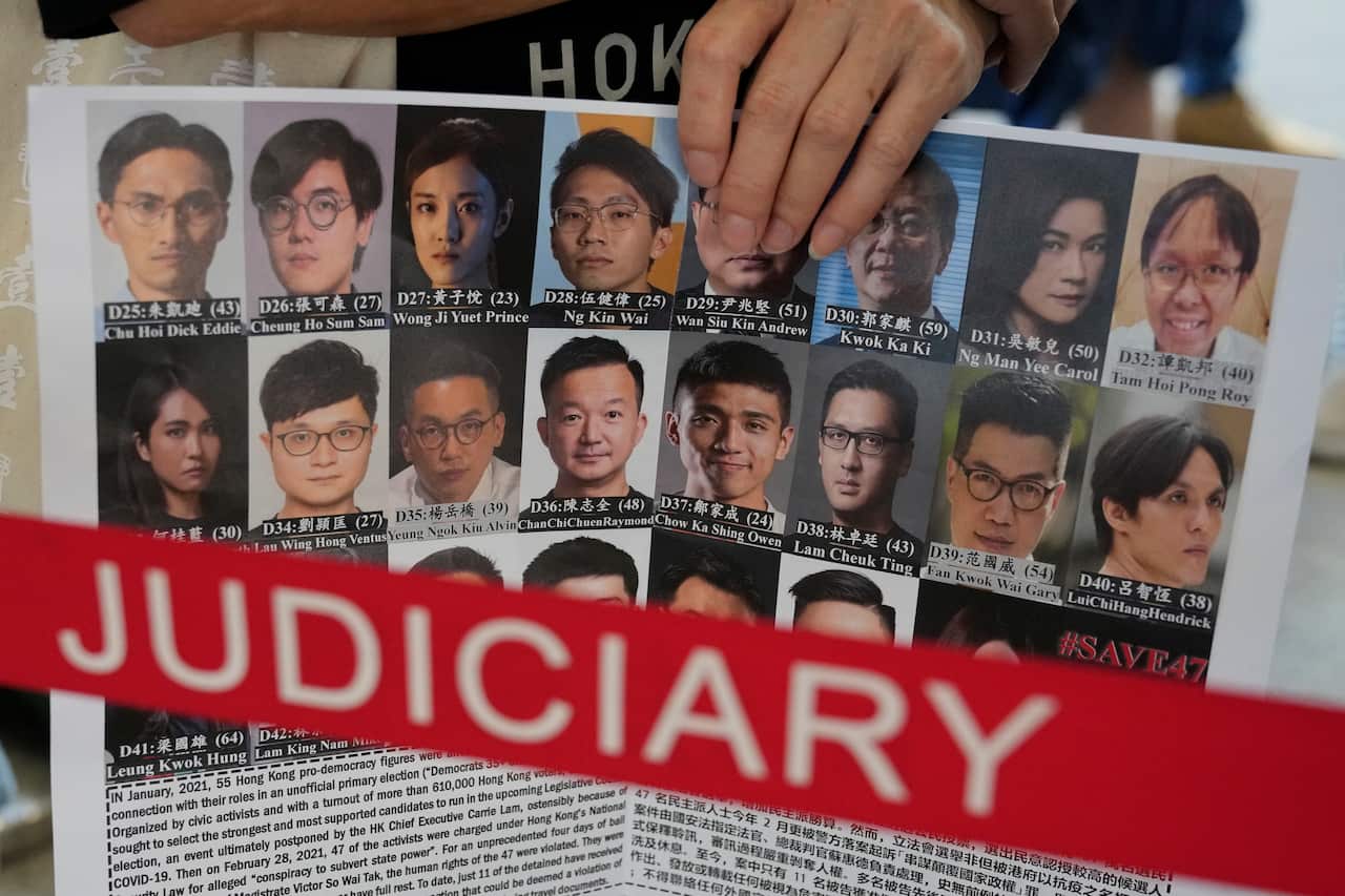 A supporter holds placard with the photos of some of the 47 pro-democracy defendants 