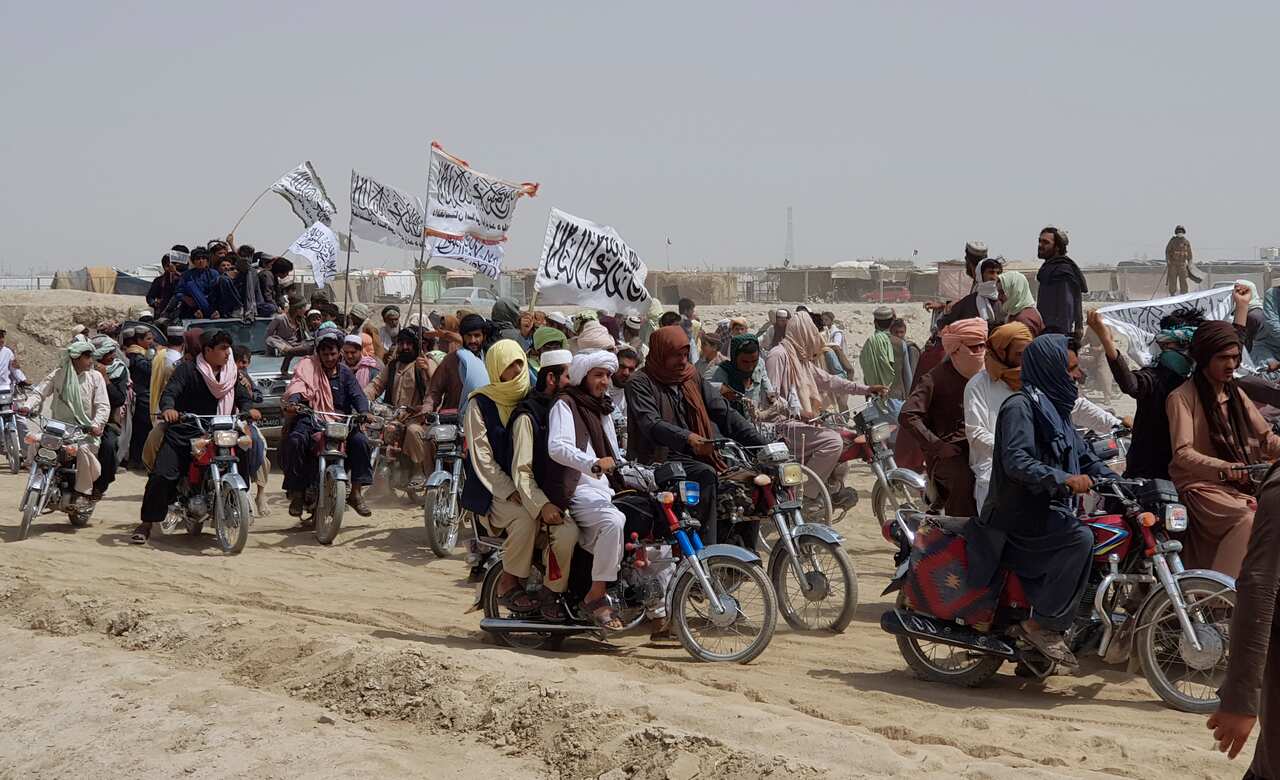 Supporters of the Taliban carry the Taliban's signature white flags in the Afghan-Pakistan border town of Chaman, Pakistan, Wednesday, July 14, 2021.