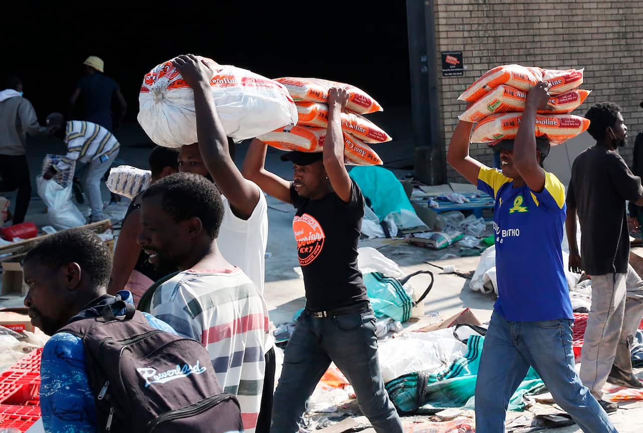 People make off with bags of rice from a factory in Mobeni, south of Durban.