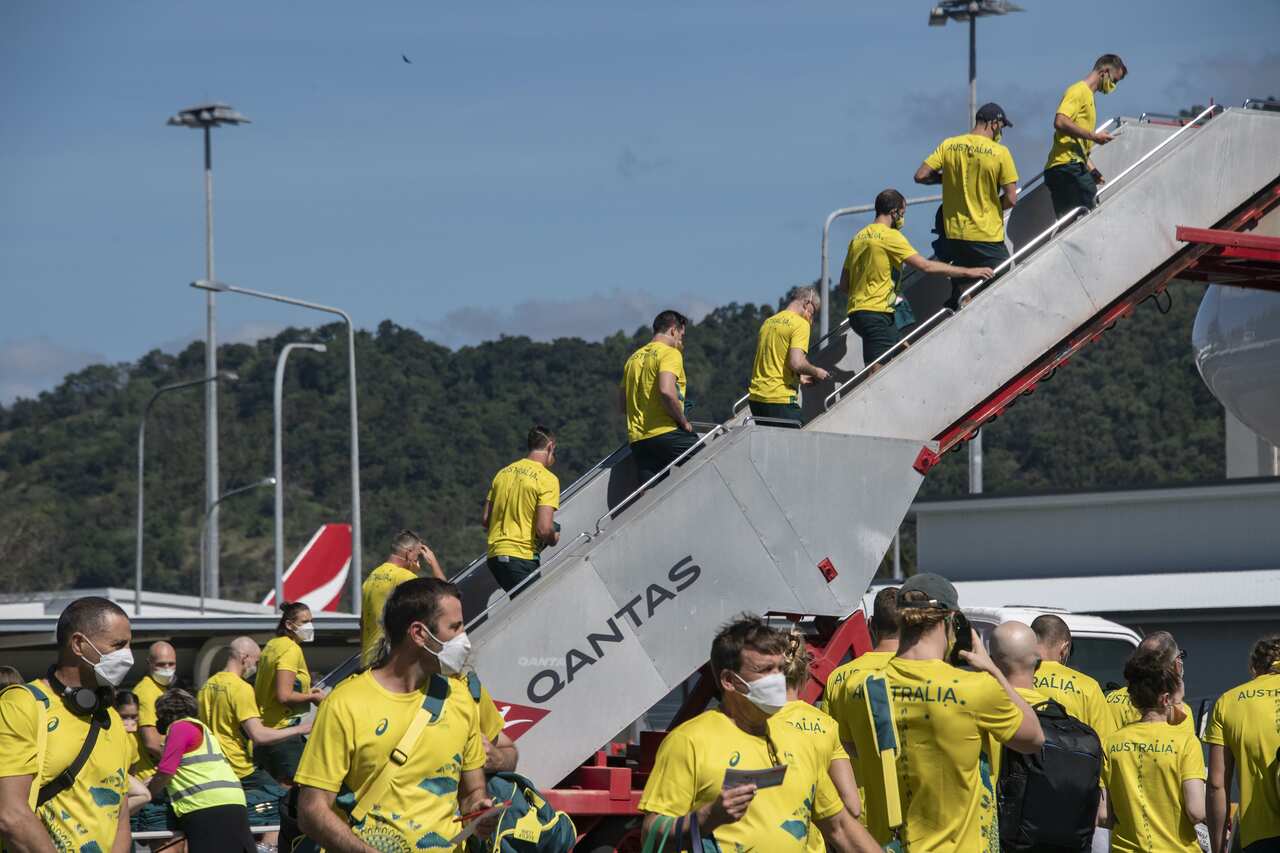 Athletes and officials of Australia's Olympic team wearing PPE face masks depart on a chartered flight from Cairns bound for the Tokyo Olympics at Cairns International Airport.