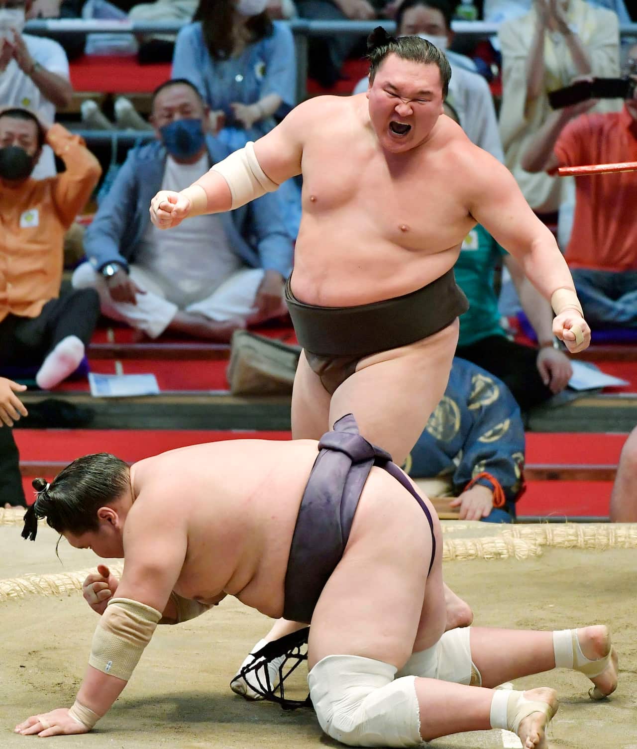 Grand champion Hakuho (top) reacts after defeating ozeki Terunofuji on the final day of the Nagoya Grand Sumo Tournament at Dolphins Arena in Nagoya, central Japan, on July 18, 2021, claiming his record 45th Emperor's Cup. (Kyodo via AP Images) ==Kyodo