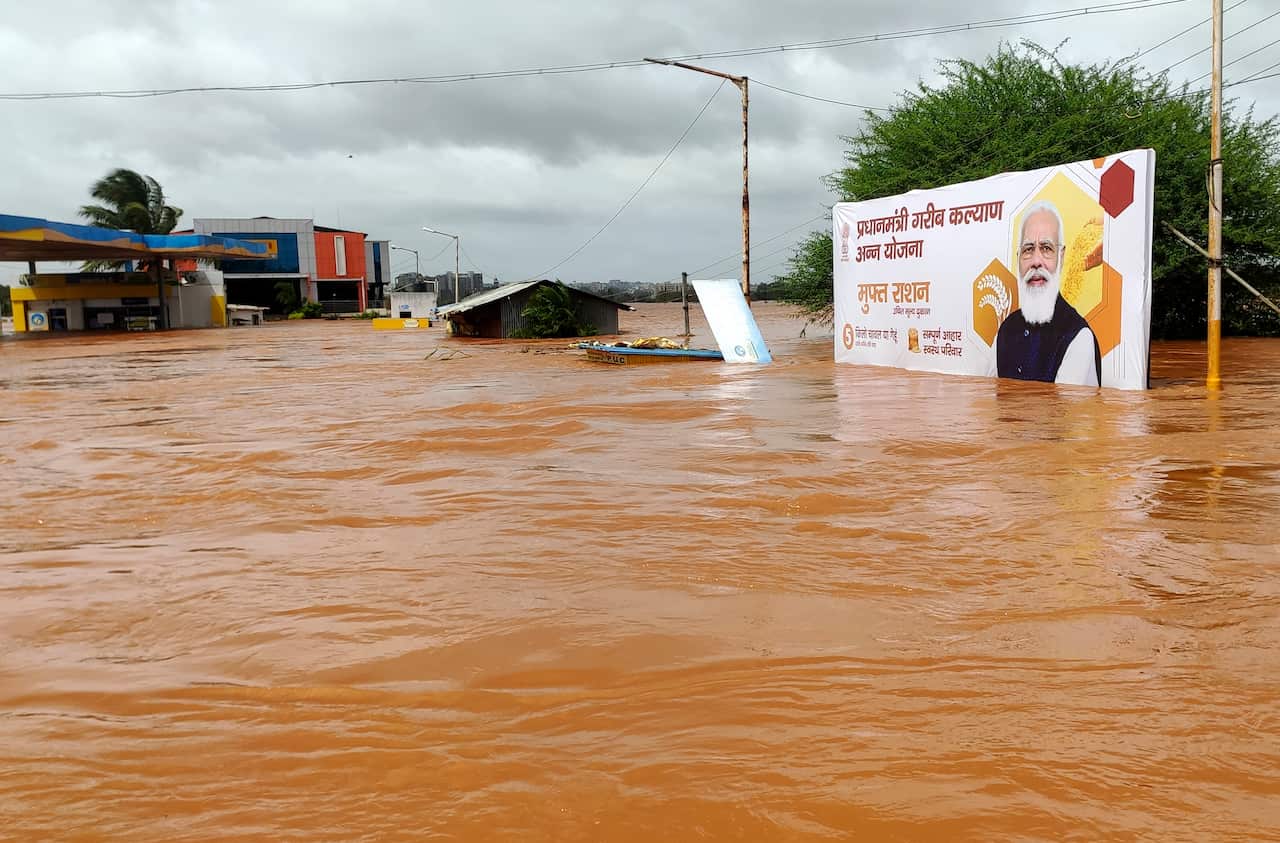 A billboard with a photograph of Prime Minister Narendra Modi is partially submerged in flood waters at Kolhapur in western Maharashtra state, 24 July, 2021.