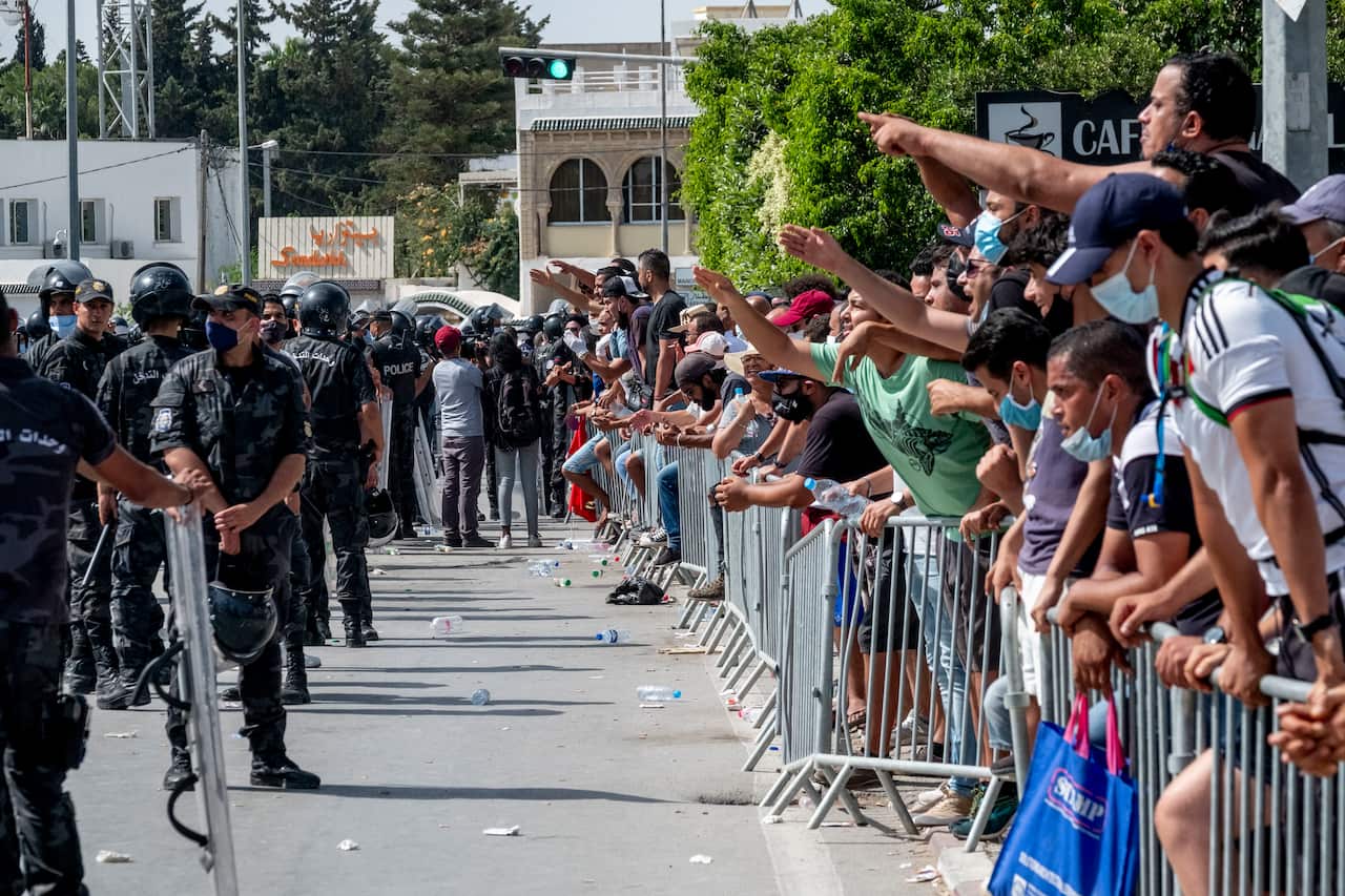 Ennahdha militants clash with supporters of Tunisian President Kais Saied under the control of the police outside the parliament and the army inside.