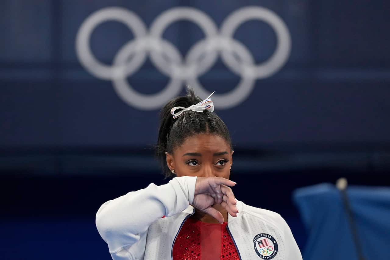 Simone Biles watches gymnasts perform at the 2020 Olympics, Tuesday, July 27, 2021, in Tokyo.