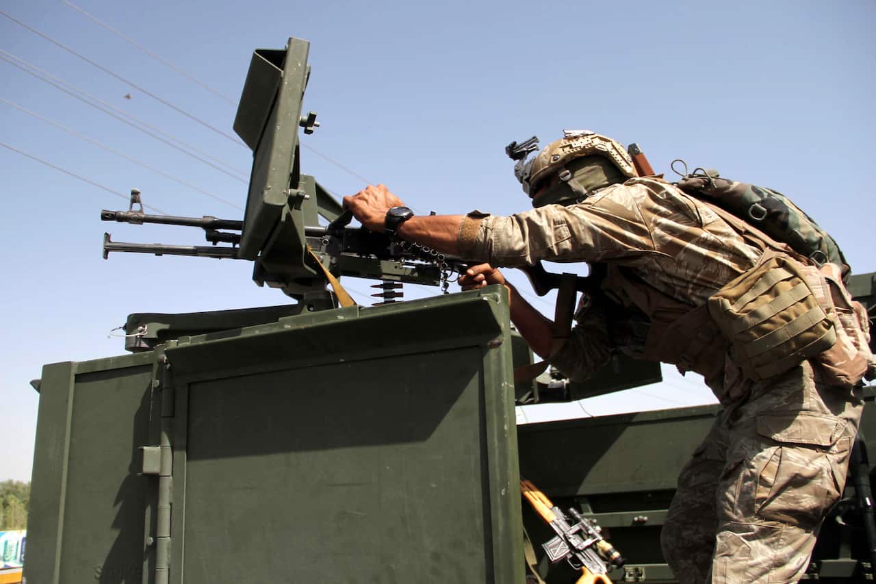 An Afghan security official stands guard at a roadside check point in Herat, Afghanistan, 31 July 2021. 